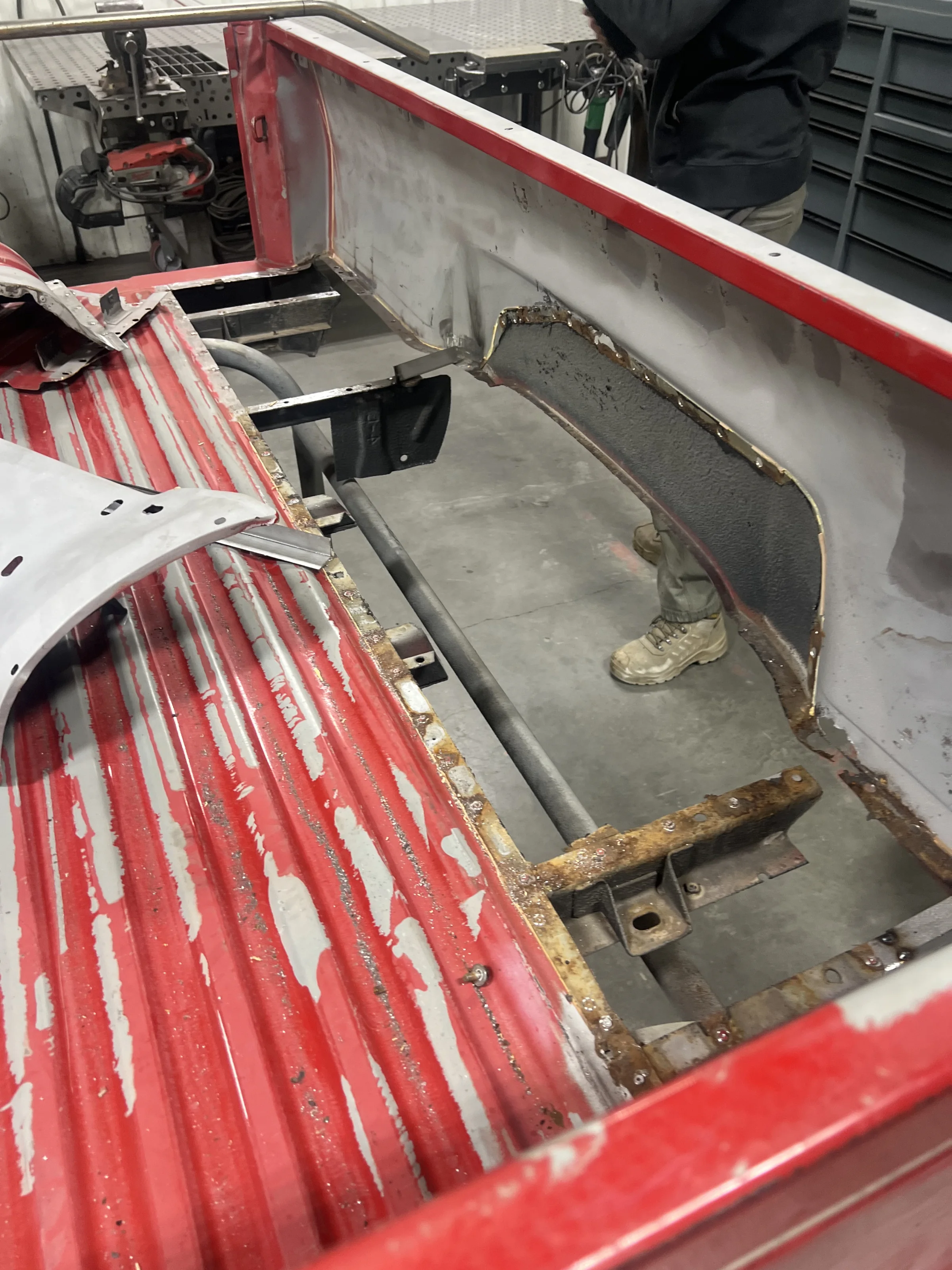 Rusty bed panels disassembled on a red 1985 Toyota Pickup