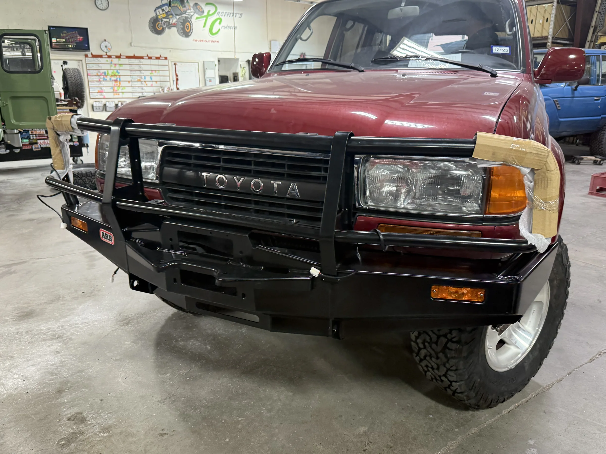 ARB front bull bar installed on the red Toyota 80 Series Land Cruiser