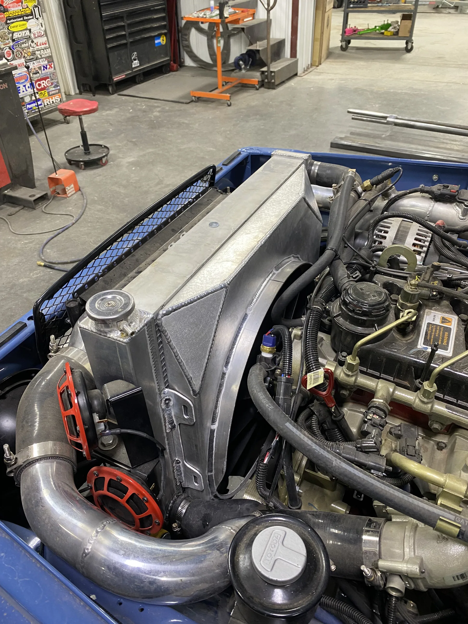 Mechanical cooling fan and custom aluminum fan shroud installed on a Cummins R2.8-powered FJ45