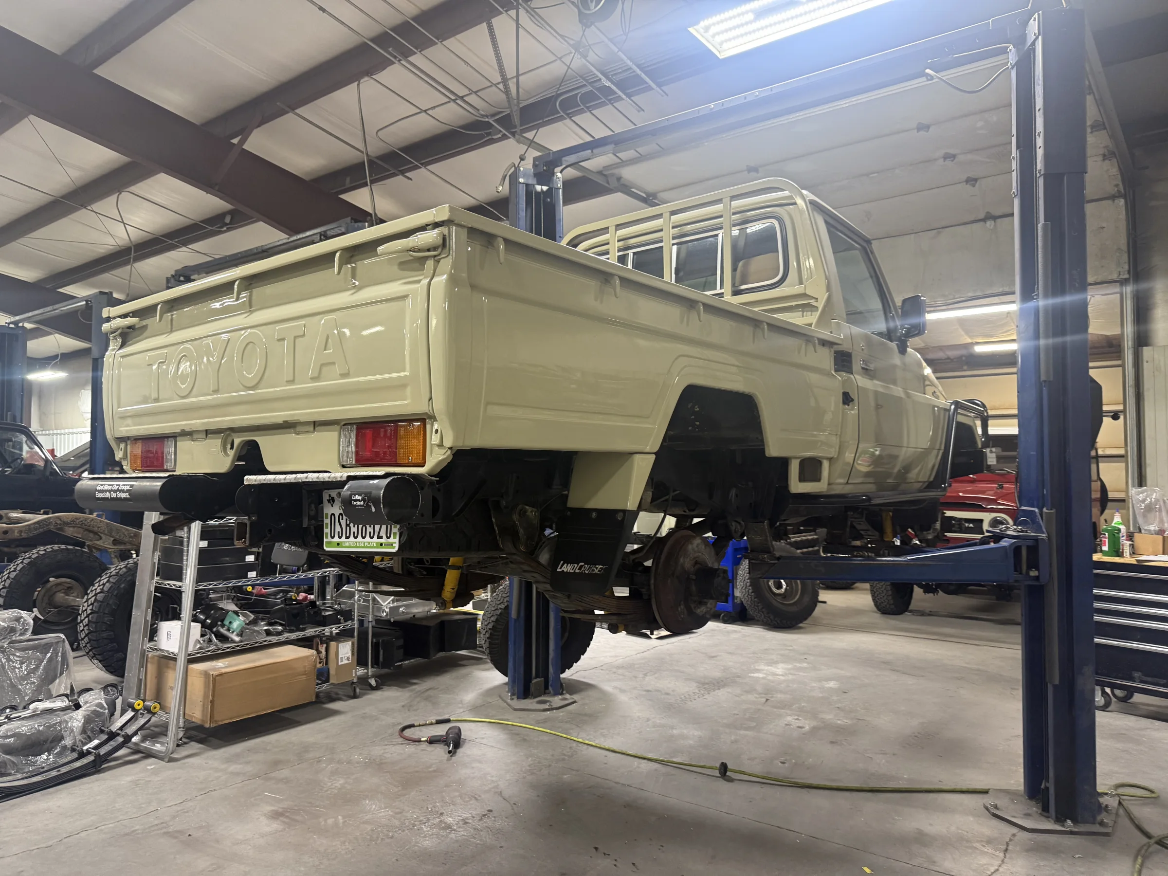 Saudi-import FZJ75 Land Cruiser Ute on a shop lift during inspection and repairs
