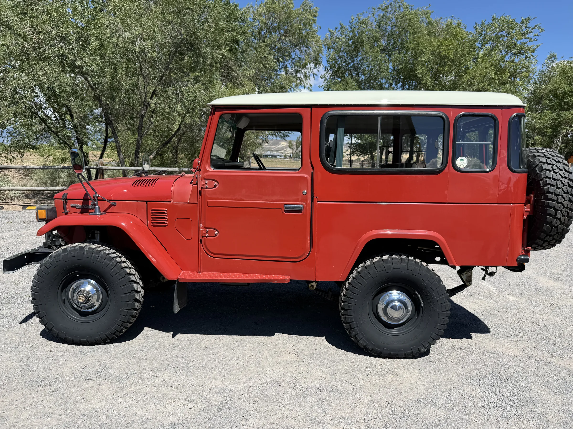 Driver-side profile of a red mid-wheelbase Toyota Land Cruiser BJ46