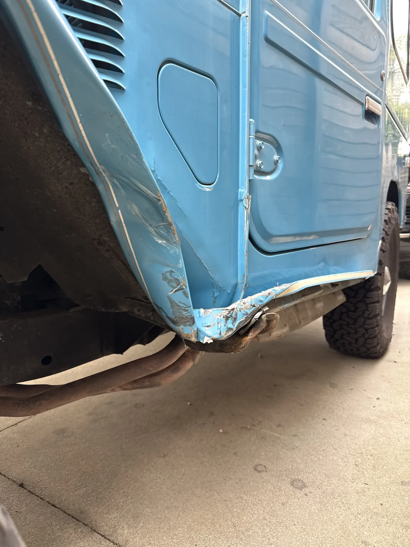 Accident and rust damage on the rear sill of a Sky Blue 1980 FJ40