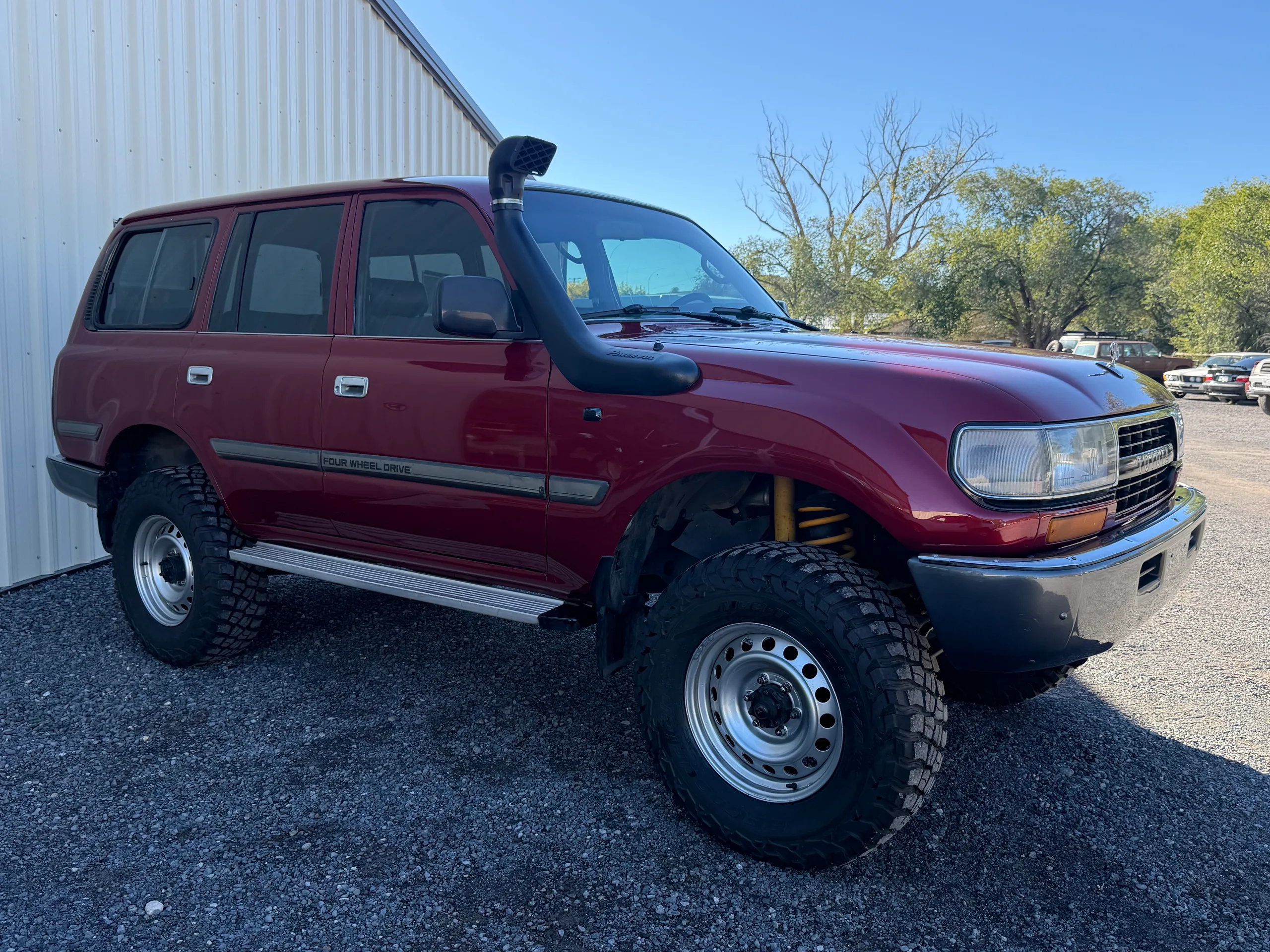 Front passenger-side view of the red FJ80 and raised air intake