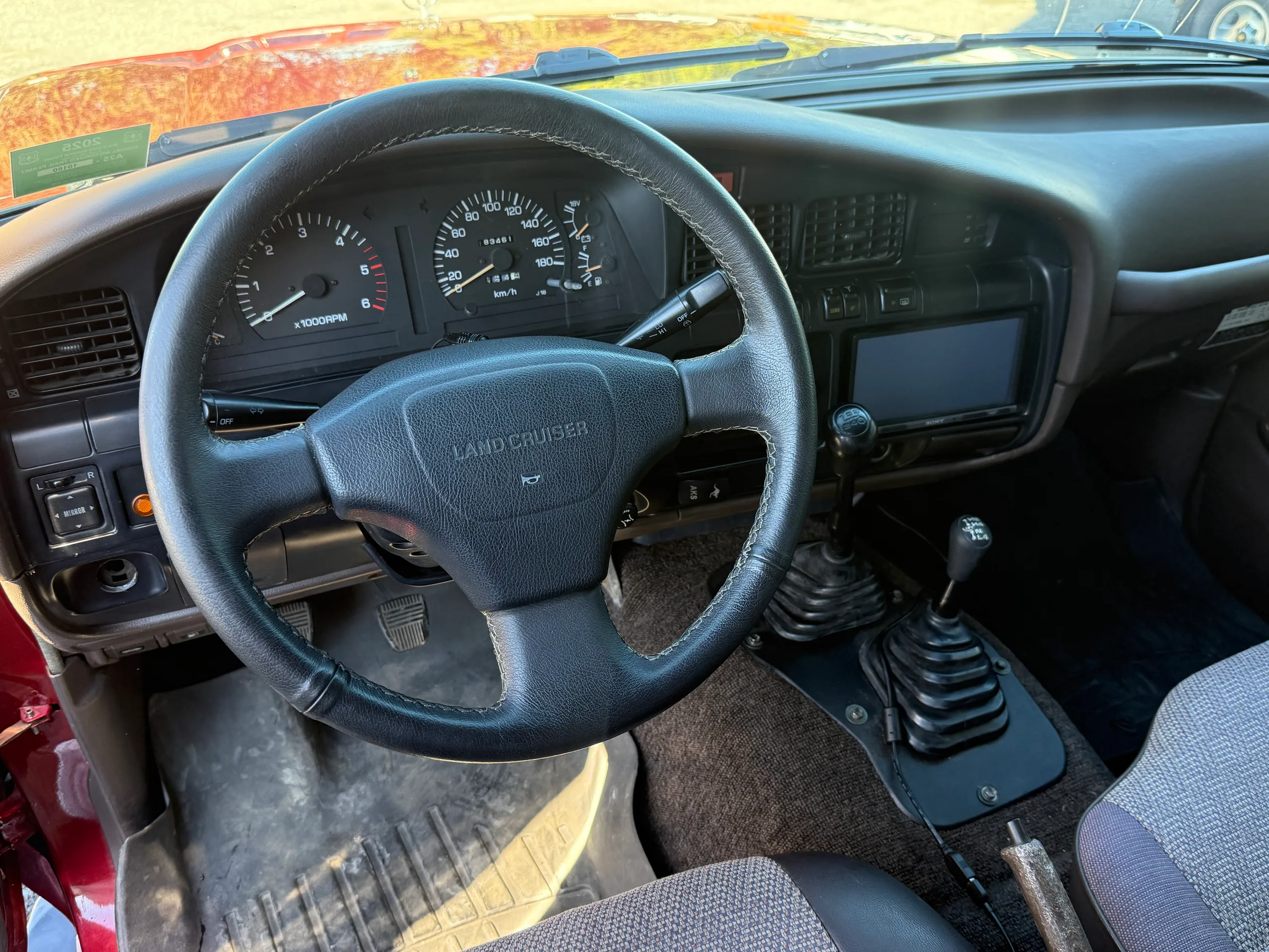 Steering wheel, dashboard, and five-speed shifter in the FJ80