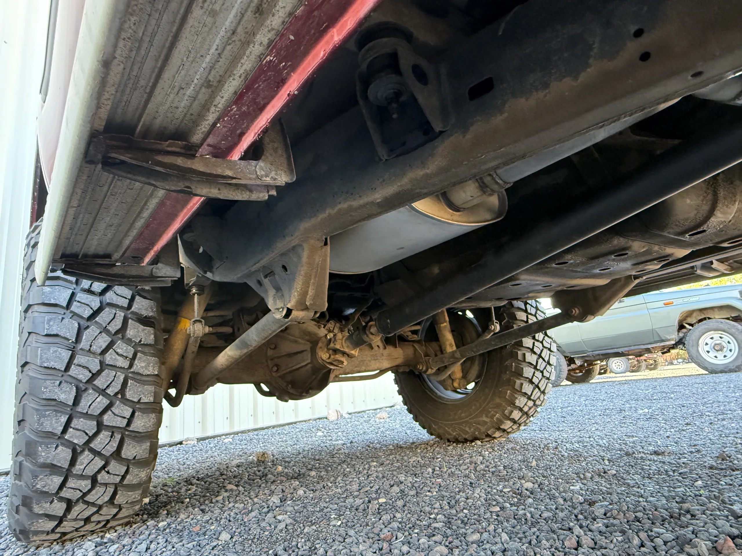 Frame rails, driveline, and exhaust beneath the 1990 FJ80