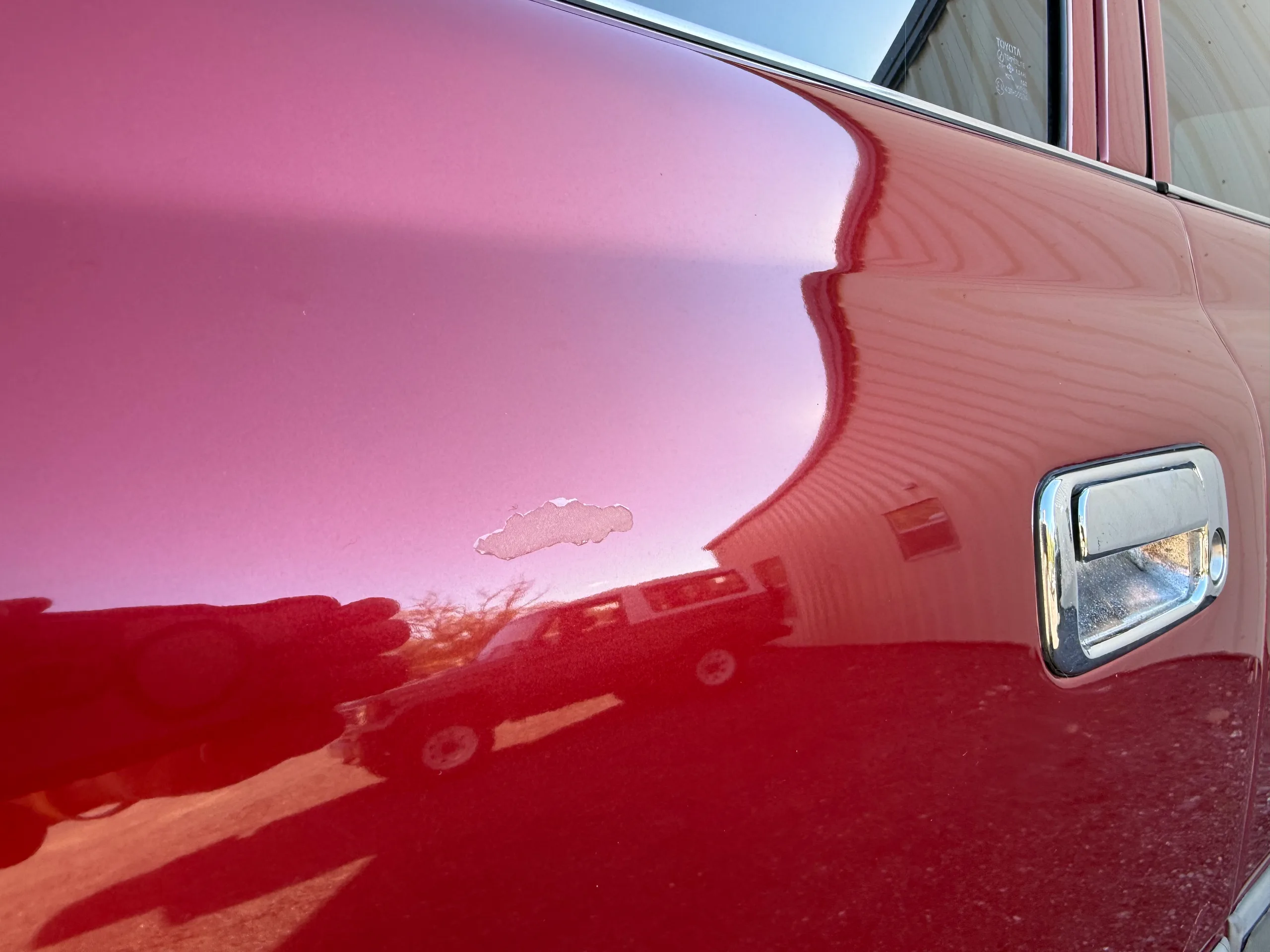Small paint blemish beside the fuel door on the red FJ80