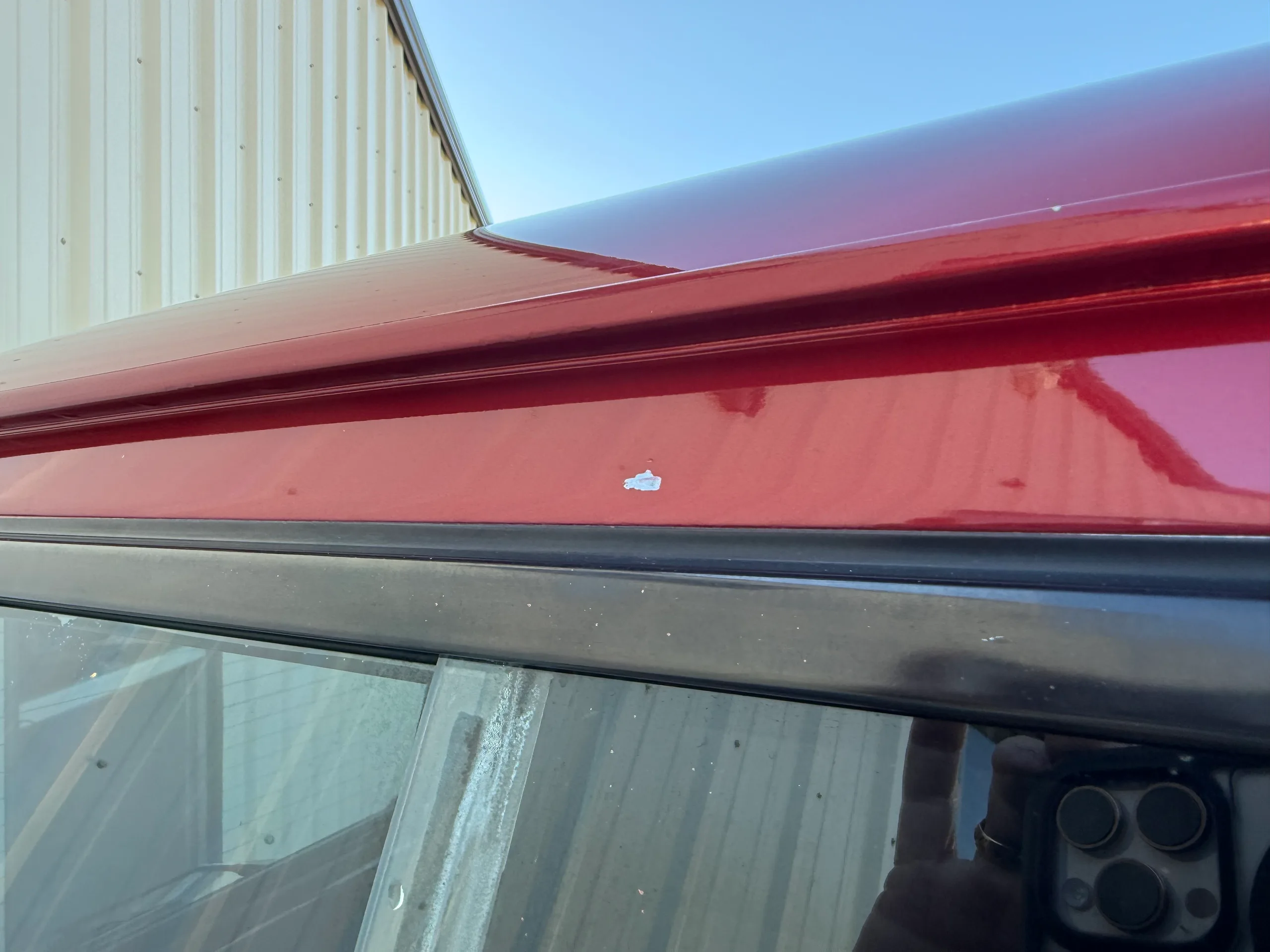 Small paint blemish along the roof edge of the red FJ80