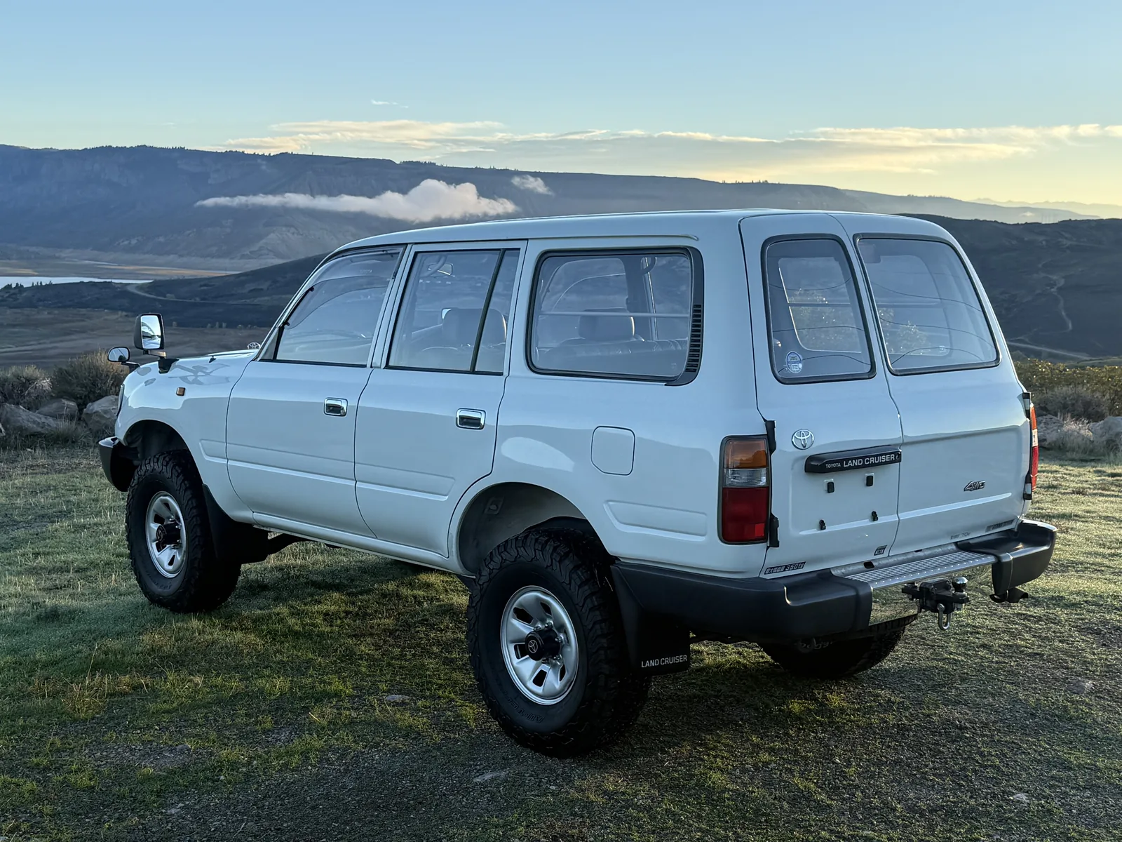 Rear driver-side view of the white HZJ81 Land Cruiser