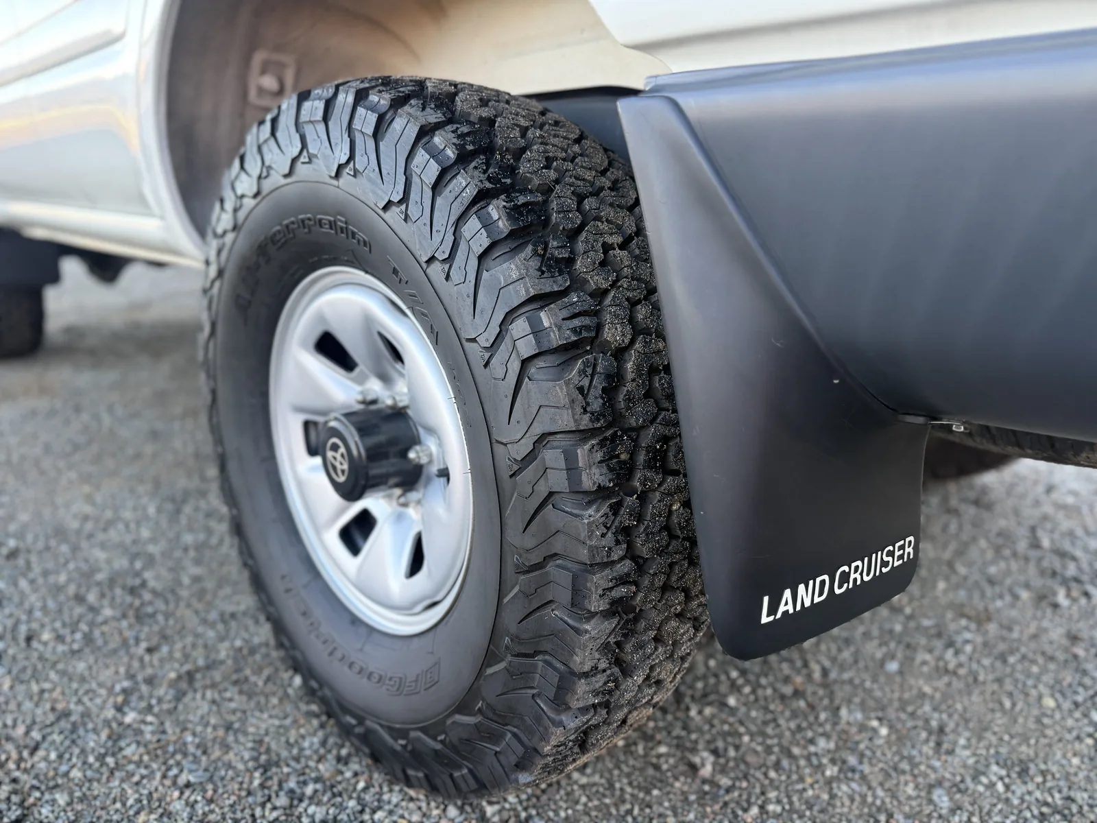 Front steel wheel, tire, fender flare, and Land Cruiser mud flap