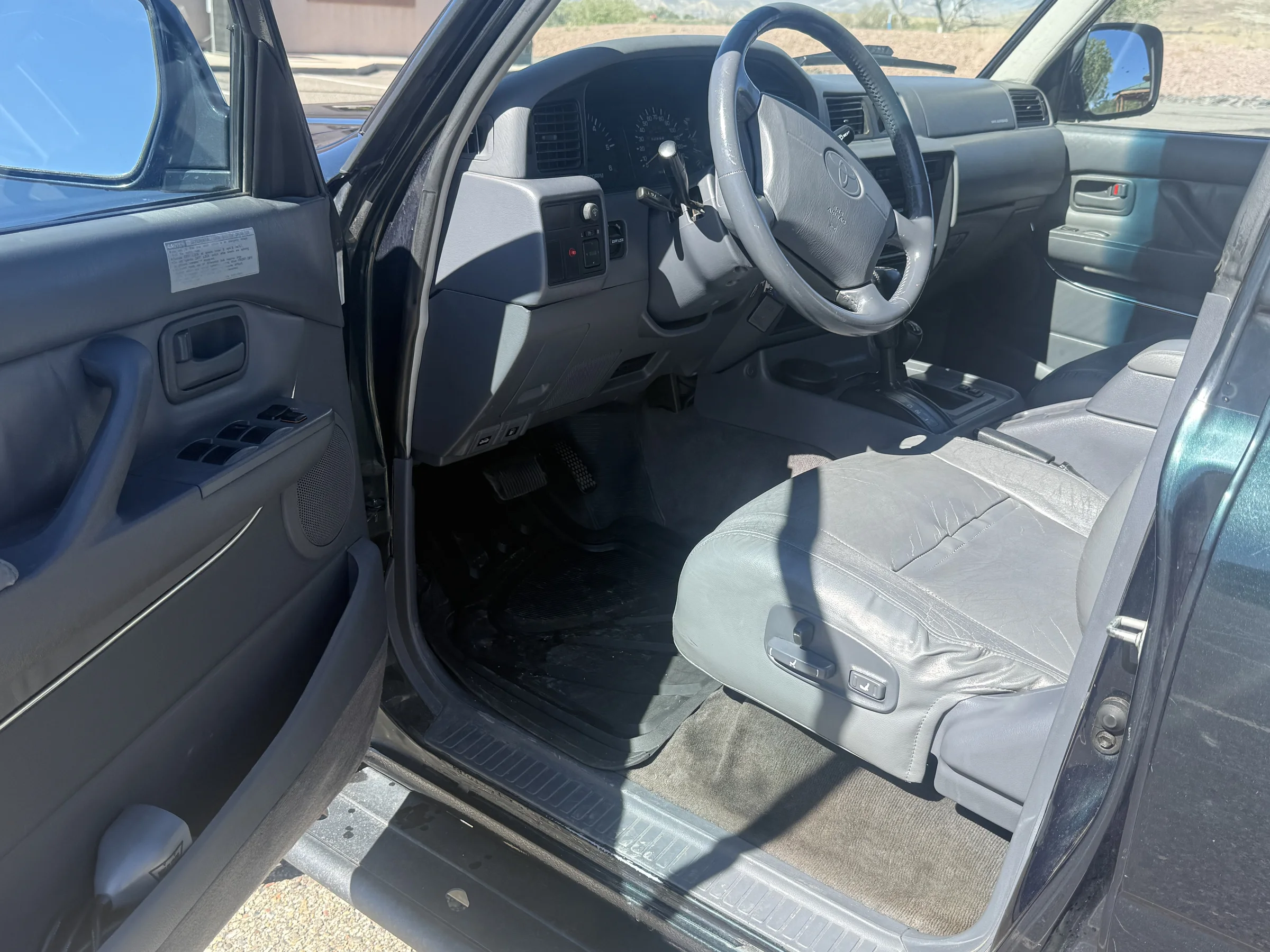 Open driver door and front cabin of the 1996 FZJ80