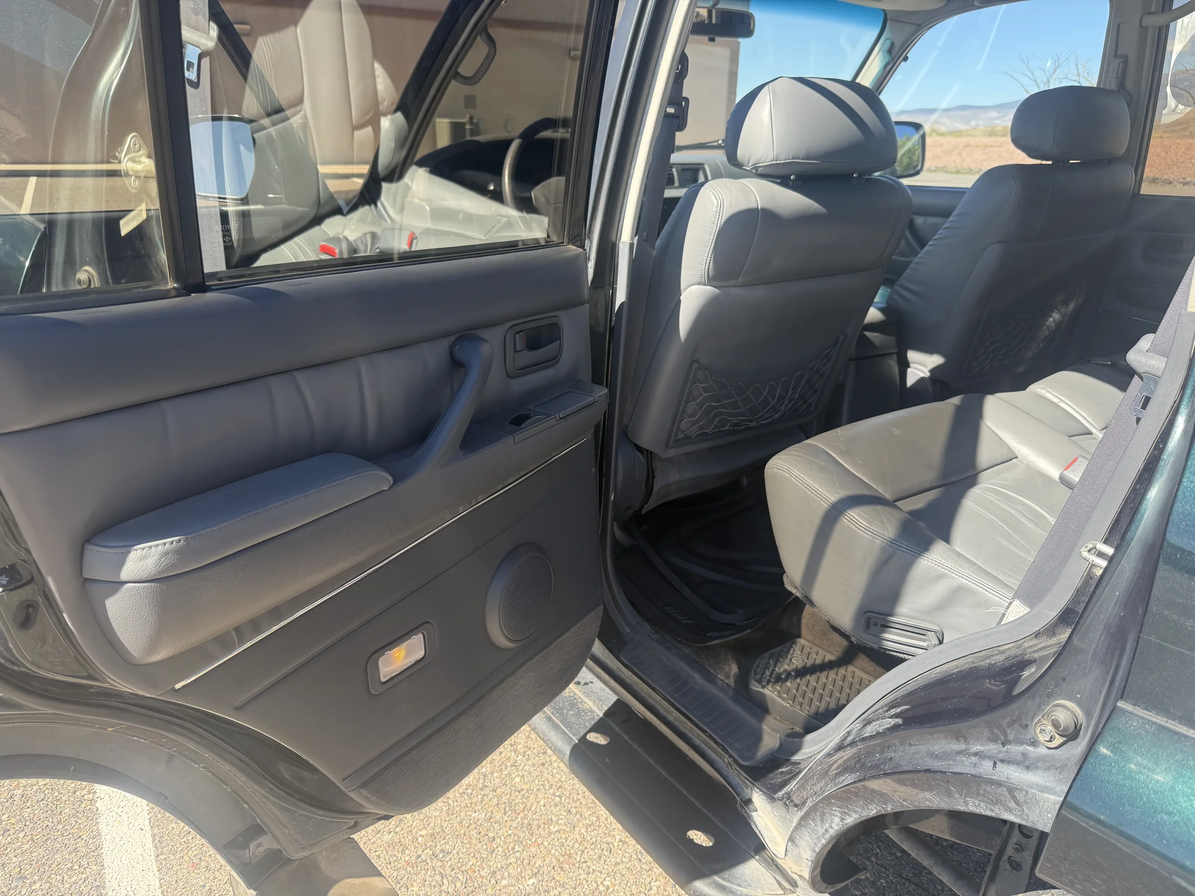 Open rear driver-side door and second-row seating in the 1996 FZJ80