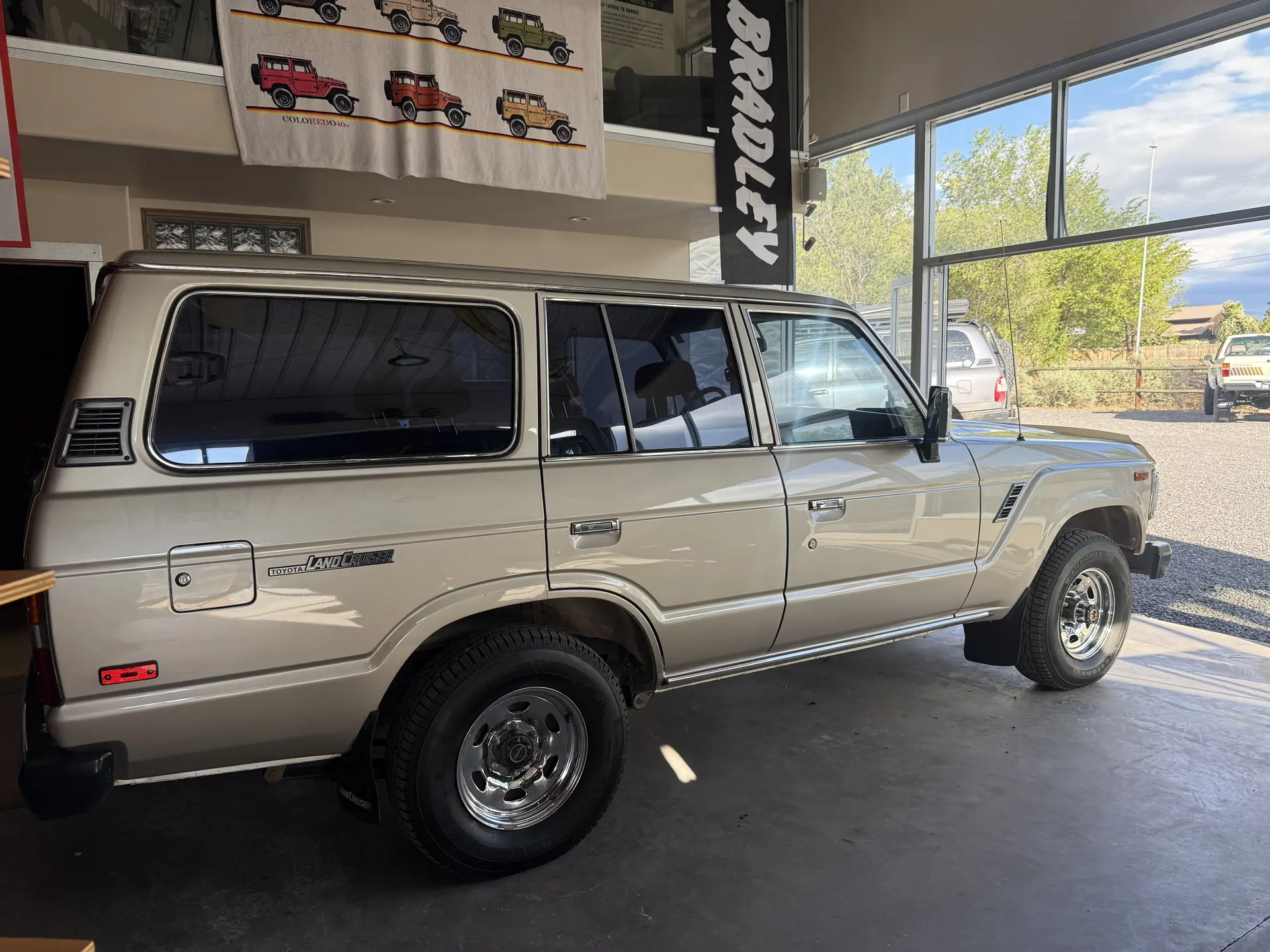 Rear passenger-side view of the 1990 Toyota FJ62 Land Cruiser inside the shop