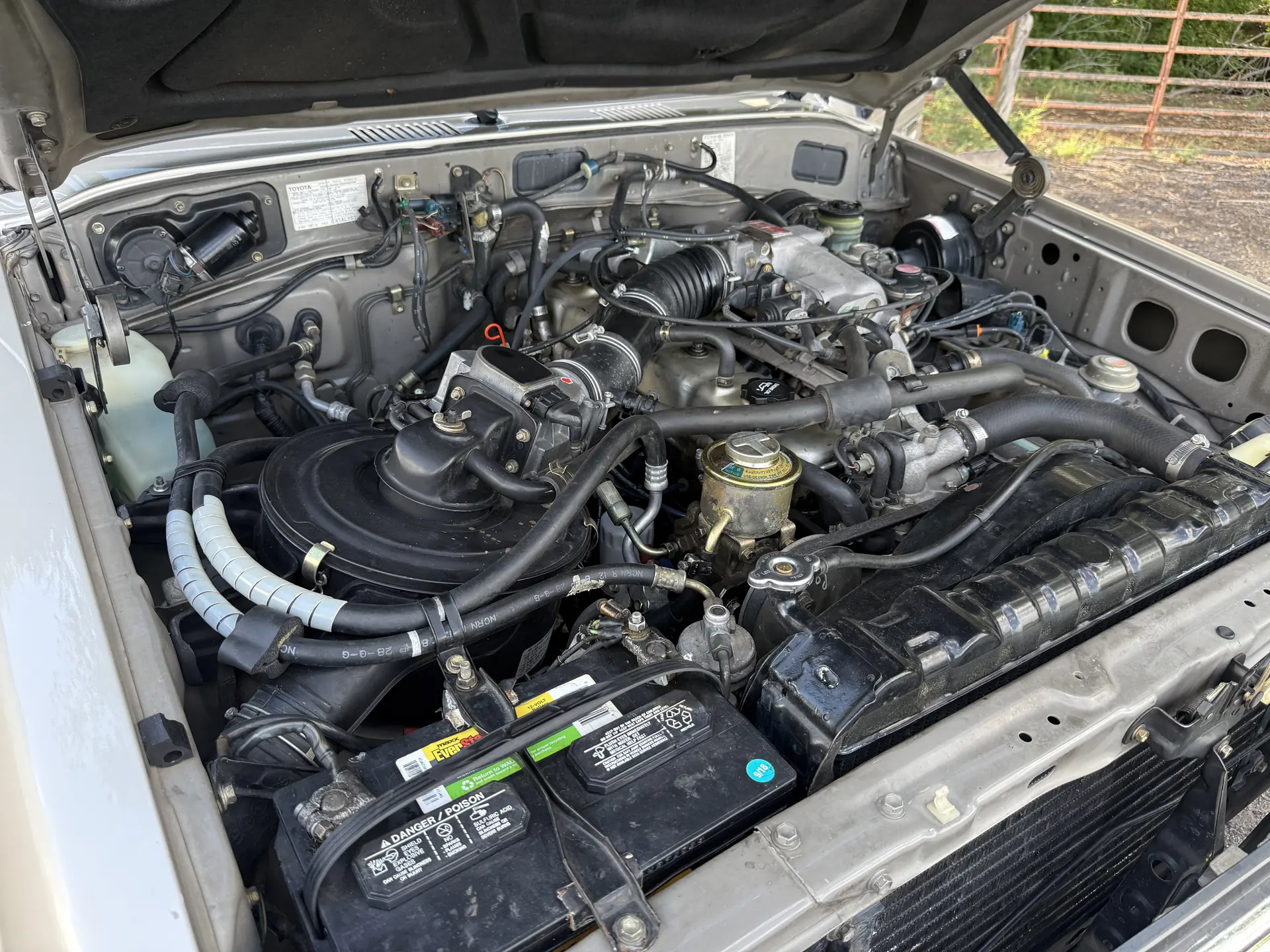 Engine bay, battery and intake of the 1990 Toyota FJ62