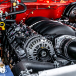 A red fj60 on an 80 series chassis, image shows a close up of the LS3/H55F Toyota five speed engine with the hood up